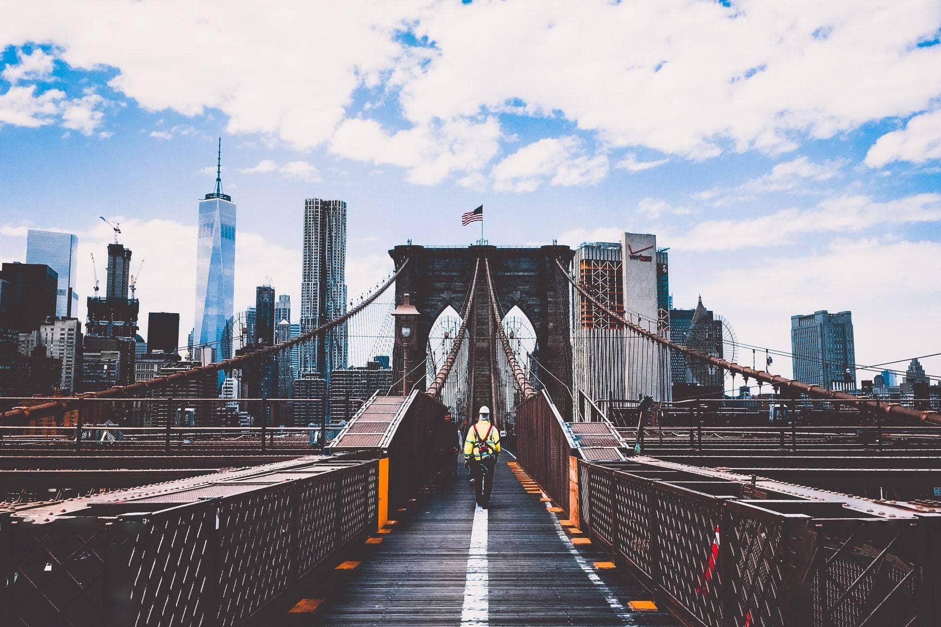 Trabajador de la construcción caminando por el puente de Brooklyn.